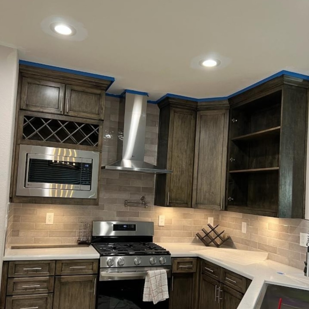 corner of a kitchen built by all pro builders - chrome appliances